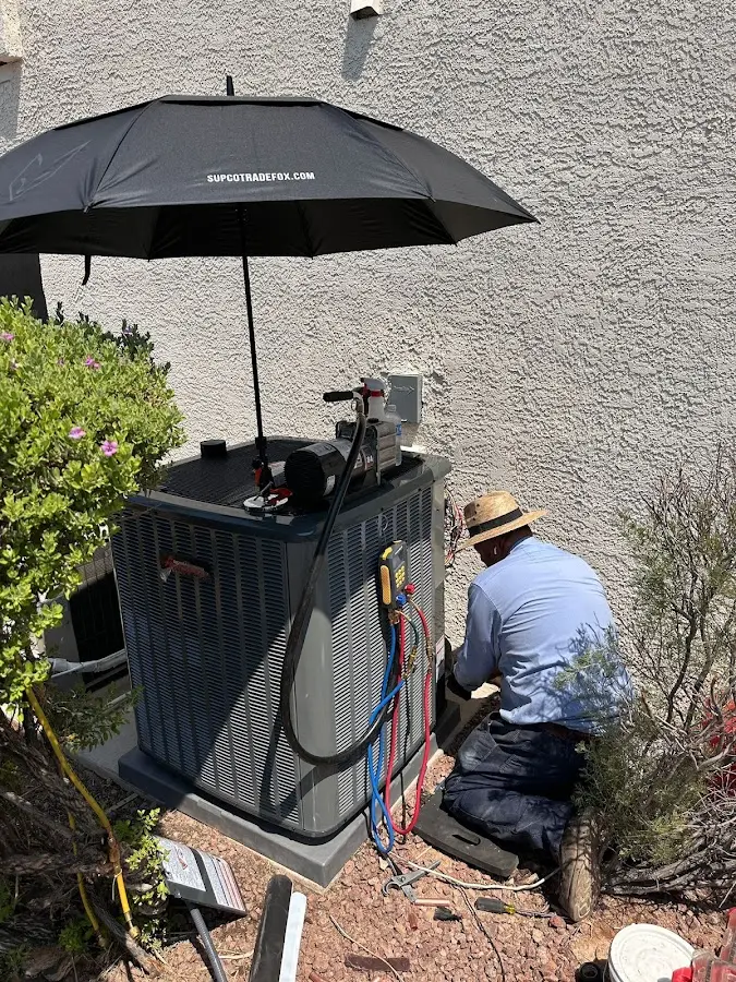 HVAC technician performing outdoor AC maintenance in Maynard